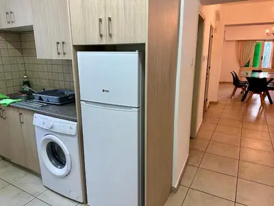 a kitchen with a refrigerator and a washing machine at Private room in shared flat in Nicosia