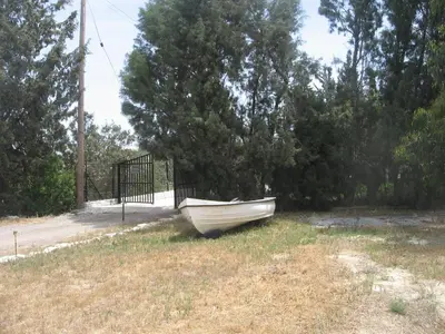 a boat sitting in the grass next to a gate at Zena Holiday Villa in Pissouri
