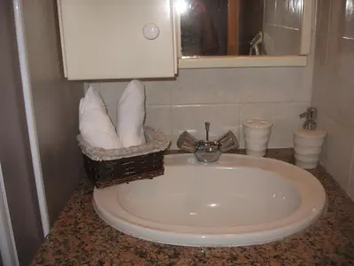 a bathroom sink with a basket of towels at Zena Holiday Villa in Pissouri