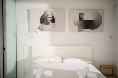 a bedroom with a bed with two pictures on the wall at Sky-view Hideaway in Nicosia