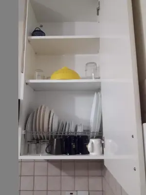 a kitchen cabinet with plates and utensils at Nicosia City Centre Apartment in Nicosia