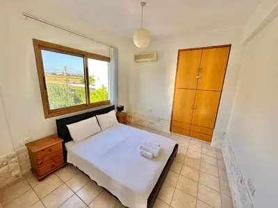 a bedroom with a white bed and a window at Lovely Pool Villa in Pyla in Pyla