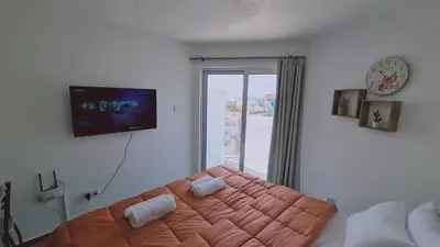 a bedroom with a bed and a large window at STAY Napa Living Studios in Ayia Napa
