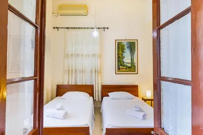 two beds in a room with a window at Theodorou Stone House in Pano Lefkara