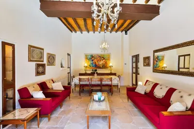 a living room with red couches and a table at Theodorou Stone House in Pano Lefkara