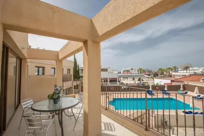 a balcony with a table and a view of a pool at Ayia Napa Holiday Apartment Na101 in Ayia Napa
