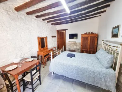 a bedroom with a bed and a table and a desk at Athena's Pool Oasis in Skarinou