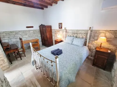 a bedroom with a bed with a blue suitcase on it at Athena's Pool Oasis in Skarinou