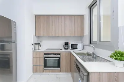 a white kitchen with a sink and a microwave at Mirage 2-BR Apartment in Larnaca in Larnaka
