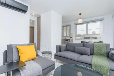 a living room with a gray couch and yellow pillows at Mirage 2-BR Apartment in Larnaca in Larnaka