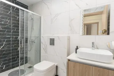 a bathroom with a toilet and a sink and a shower at Mirage 2-BR Apartment in Larnaca in Larnaka