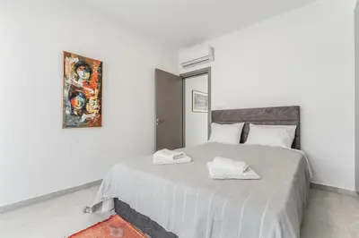 a white bedroom with a bed with two towels on it at Imperial Jade V2 - Villa Semeli in Protaras in Paralimni