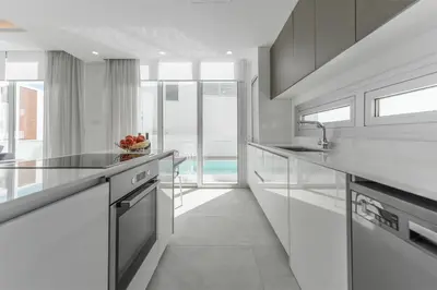 a kitchen with white counters and a large window at Imperial Jade V2 - Villa Semeli in Protaras in Paralimni