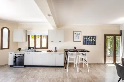 a kitchen with white cabinets and a table at SunnyVillas: 4BR SeaFront Villa*Private Pool*BW44 in Protaras