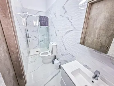 a white bathroom with a toilet and a sink at Giorgis Luxury Apartments in Ayia Napa