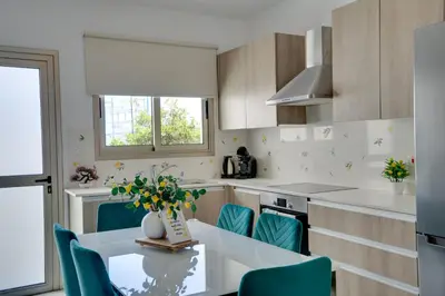 a kitchen with a table and some blue chairs at Lemon Paradise City centre 200m from beach in Larnaka