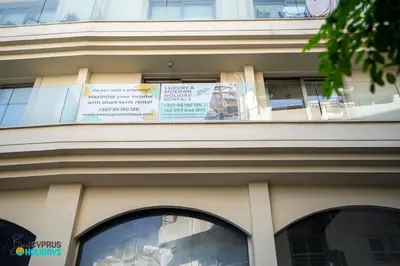 a building with a balcony with a sign on it at Lemon Paradise City centre 200m from beach in Larnaka