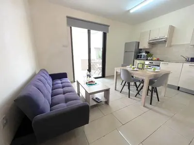a living room with a purple couch and a table at Antiparos 1 bedroom APT Kyklades in Paralimni