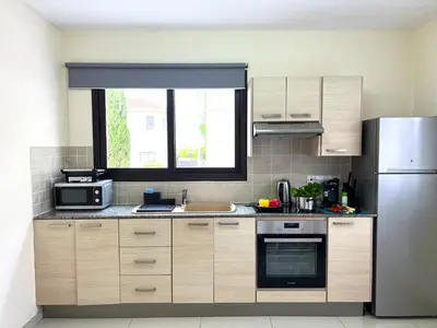 a kitchen with a sink and a refrigerator at Paros 1 bedroom APT Kyklades in Paralimni