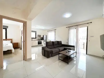 a living room with a couch and a table at Paros 1 bedroom APT Kyklades in Paralimni