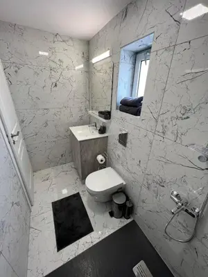 a bathroom with a toilet and a sink and a mirror at Amalia Residences in Nicosia