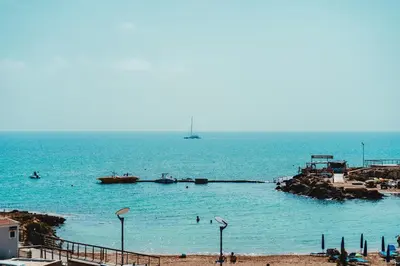 a beach with boats and people in the water at Protaras Beachfront Villa Blue Waves in Protaras