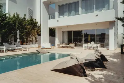 a house with a swimming pool and a building at Protaras Beachfront Villa Blue Waves in Protaras