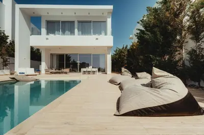 a house with a swimming pool in front of a house at Protaras Beachfront Villa Blue Waves in Protaras
