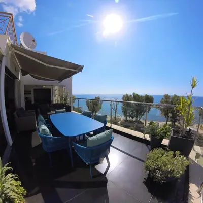 a balcony with a blue table and chairs and the ocean at The View Beach Penthouse in Limassol