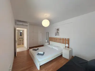 a bedroom with a large white bed and a lamp at Sunny Breeze in Ayia Napa