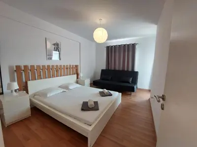 a bedroom with a bed and a black chair at Sunny Breeze in Ayia Napa