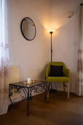 a living room with a green chair and a table at Morfeas Kakopetria in Kakopetria