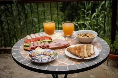 a table with a plate of food and two glasses of orange juice at Morfeas Kakopetria in Kakopetria