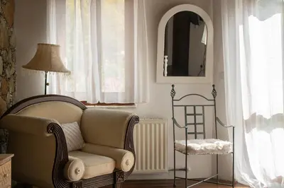 a living room with a chair and a mirror at Morfeas Kakopetria in Kakopetria