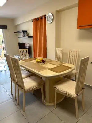 a dining room table and chairs with a bowl of fruit on it at Mezzarina apartment ayia napa in Ayia Napa