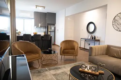 a living room with a couch and chairs and a kitchen at Glamorous, Renovated 3-Bedroom Apt in Nicosia in Nicosia