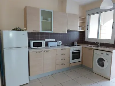 a kitchen with a white refrigerator and a dishwasher at Pyla Palms Resorts A2 102 in Pyla