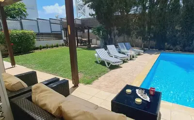 a swimming pool with chairs and a couch next to a pool at VILLA MARINA BY FIG TREE BAY in Protaras