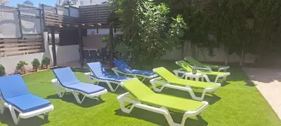 a group of lawn chairs sitting on the grass at VILLA MARINA BY FIG TREE BAY in Protaras
