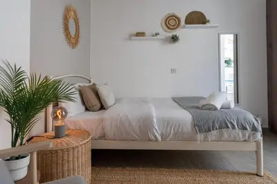 a bedroom with a bed with white walls at Orchid's Cozy Studio & Balcony in Larnaca in Larnaka