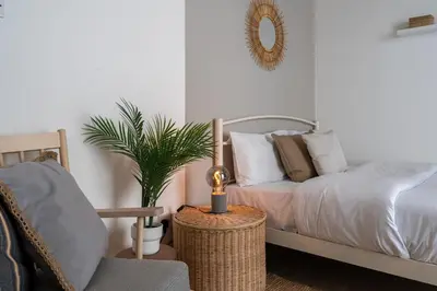 a bedroom with a bed with a mirror and a chair at Orchid's Cozy Studio & Balcony in Larnaca in Larnaka