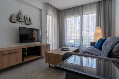 a living room with a couch and a tv at A Blissful 1-Bedroom Voyage in Larnaca in Larnaka