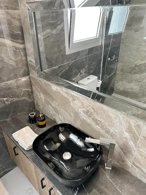 a bathroom with a black toilet and a sink at City Lights - Luxury Penthouse - Panoramic view - Near Unic in Nicosia