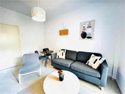 a living room with a blue couch and a table at LINA 25 in Larnaka