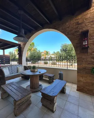 an outdoor patio with wooden benches and a table at Sotira Agia Napa Luxury House in Ayia Napa