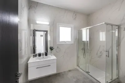 a white bathroom with a shower and a sink at Napa Bay View Villa 8 in Ayia Napa