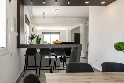 a kitchen and dining room with a bar with stools at Napa Bay View Villa 8 in Ayia Napa