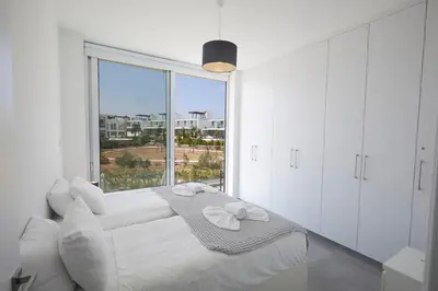 a white room with a bed and a large window at Protaras Olivine Villa Ol01 in Paralimni