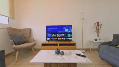 a living room with a tv and a couch and a table at STAY Mermaid's Cove in Limassol