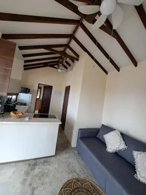 a living room with a blue couch and a kitchen at Sunset Retreat Cyprus in Pendakomo